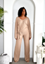 Woman wearing beige ribbed knit lounge set with tie waist, standing in archway, modern decor