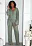 Woman modeling sage green long sleeve lounge set with wide-leg pants in modern indoor setting