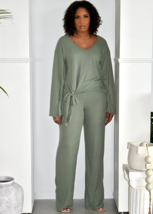 Woman wearing sage green ribbed lounge set with long sleeves and tie waist in modern interior