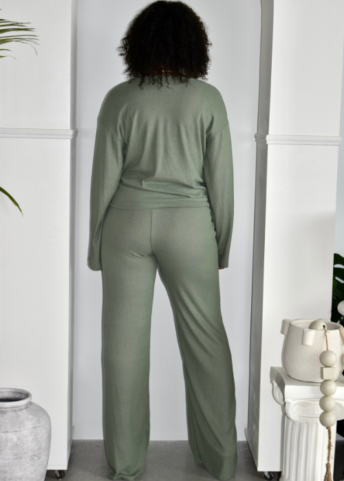 Woman in sage green ribbed lounge set with long sleeves and wide-leg pants, indoors