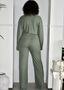 Woman in sage green ribbed lounge set with long sleeves and wide-leg pants, indoors