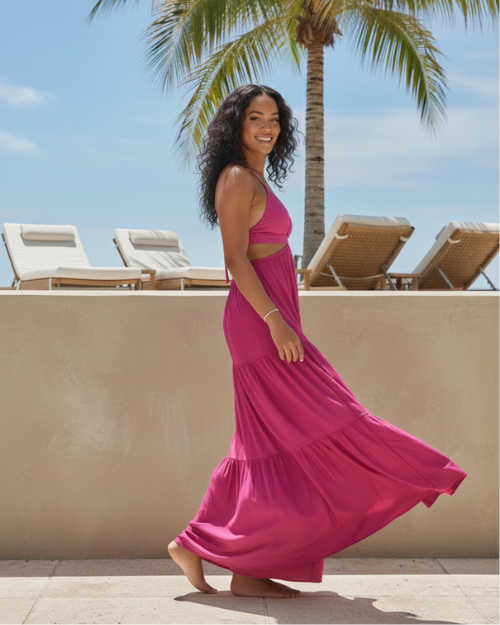 Woman in sleeveless fuchsia maxi dress by poolside with palm tree, resortwear style