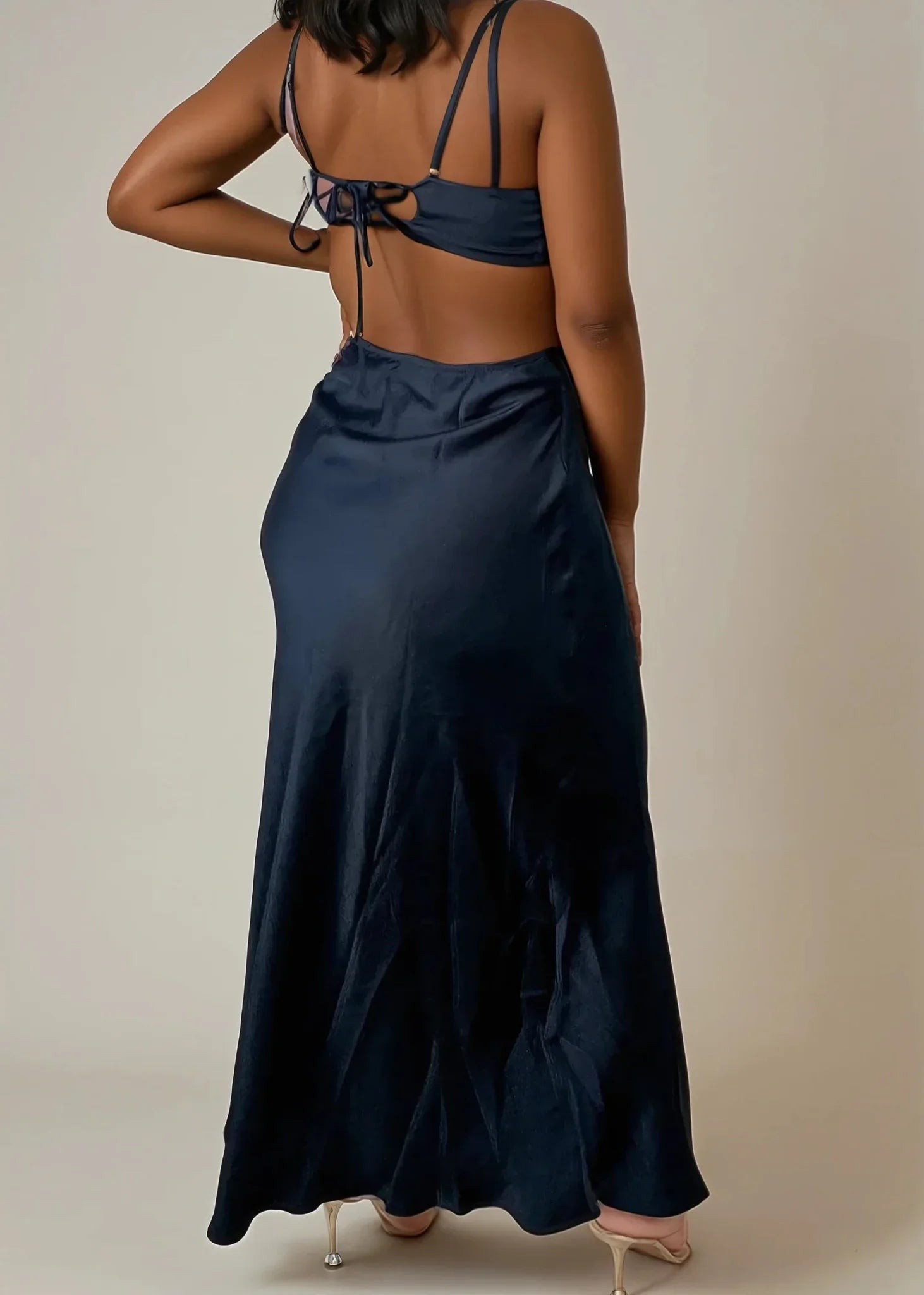 Black satin maxi dress with cut-out back details, thin straps, and tie accents.